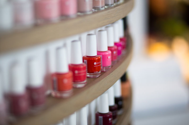 Shelf of several bright nail polish bottles.