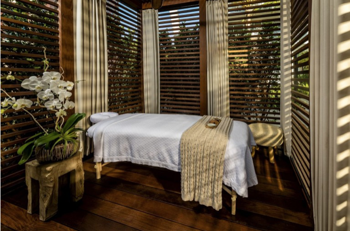 Massage treatment room with a massage table and a white orchid.