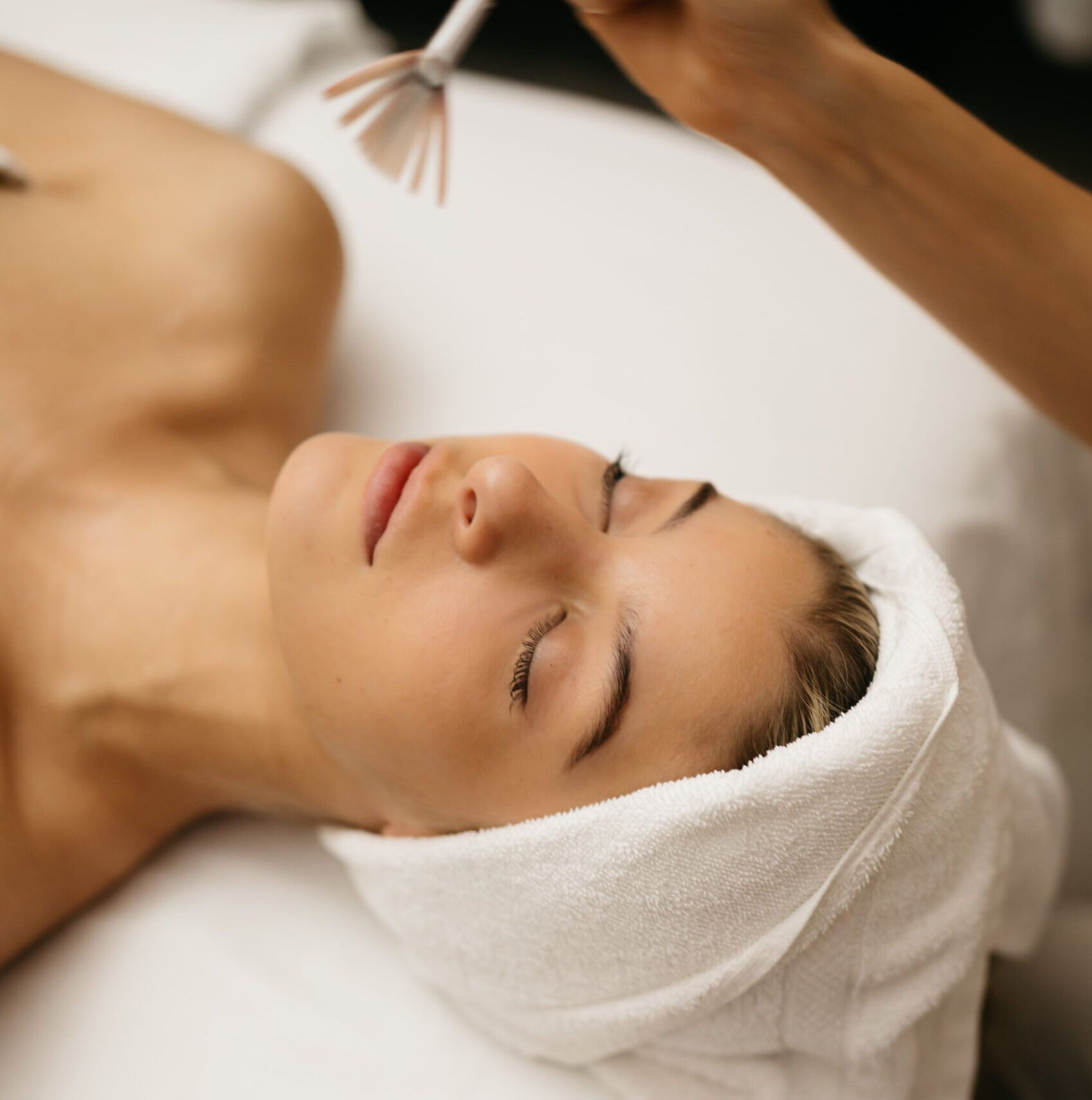 Woman laying on a spa treatment table receiving a facial.