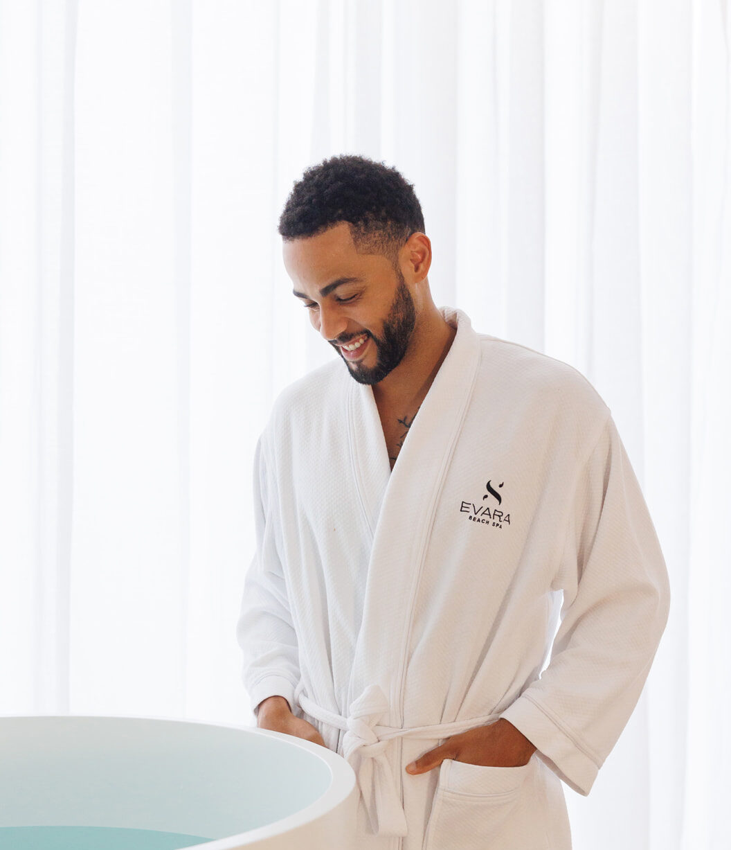 man in spa bathrobe looking at cold plunge pool