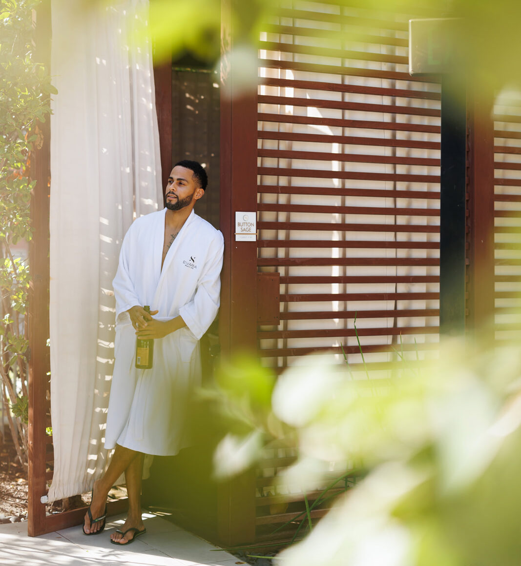 man in a spa robe standing in front of a garden cabana